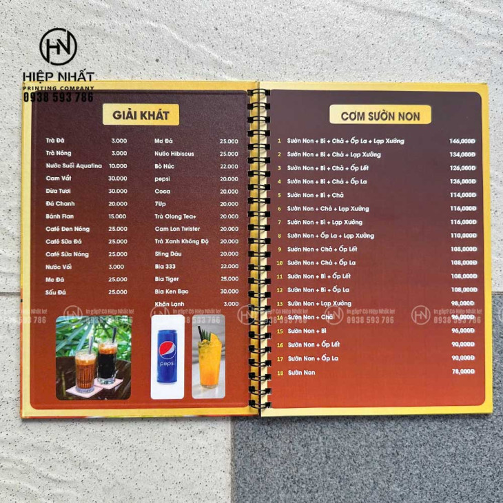Trang menu bìa cứng lò xo với danh sách cơm sườn và giải khát rõ ràng, dễ đọc